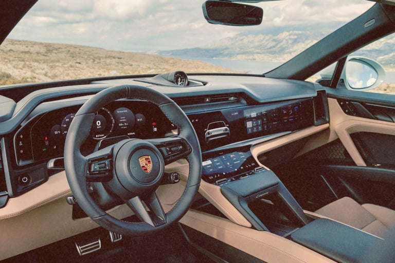 Luxury interior of a modern Porsche Cayenne featuring digital dashboard displays and leather seats.