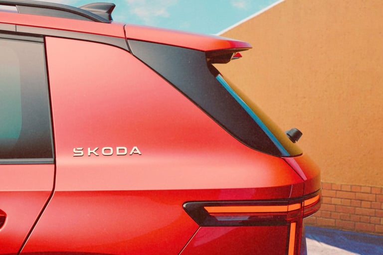 Rear view of a red Skoda SUV showing the silver brand logo and modern LED taillight design.