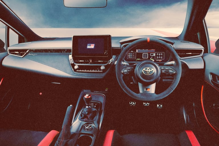 The modern interior of a Toyota GR Corolla featuring a digital dashboard and sporty red accents.