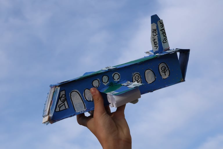 photo of Childs hand holding up cardboard airplane