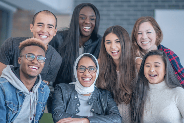 a diverse group of students standing around a table
