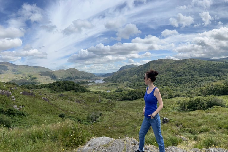 a woman standing on a rock in the mountains