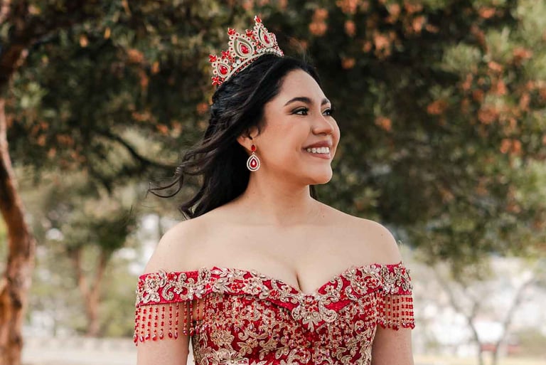 Hermoso retrato profesional de quinceaños con vestido rojo en Itchimbía Quito con naturaleza y sonrisa de felicidad