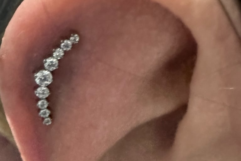 Close-up of professional helix piercing with titanium stud in Montrose