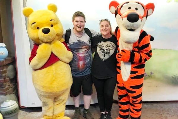 Sarah Brewer pictured with her husband, along with Winnie the Pooh and Tigger.