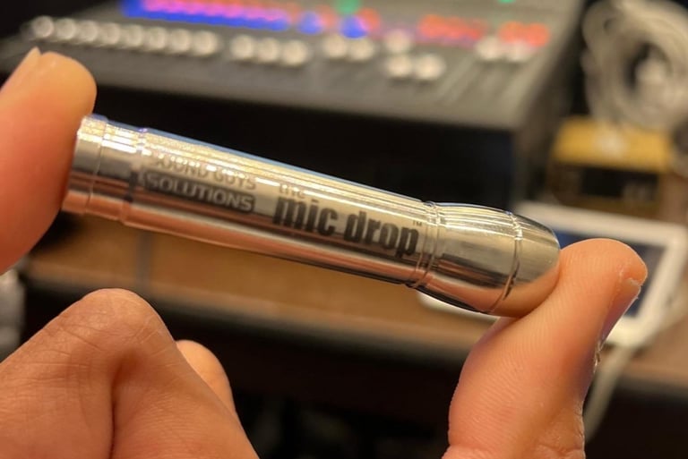 a person holding a lav mic drop in their hand
