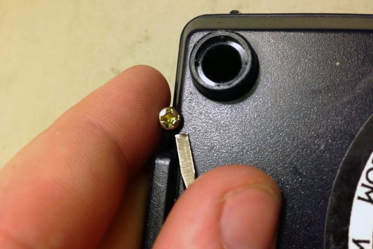 a person holding a small piece of metal with a small screwr