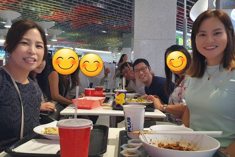 a group of Japanese people sitting at a table with smiley faces