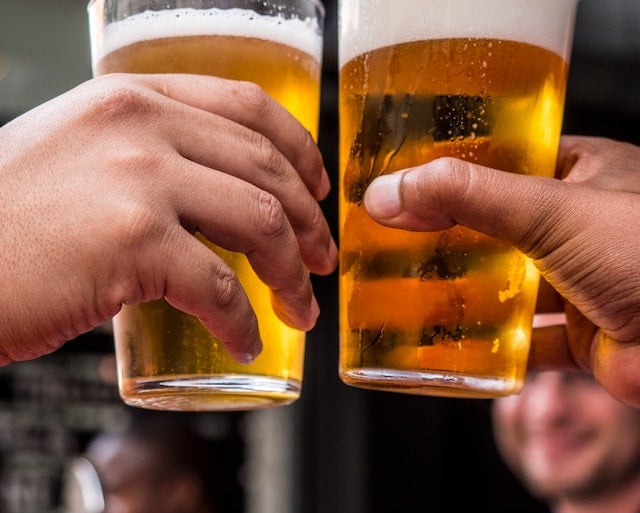 two men toasting with beer glasses of beer