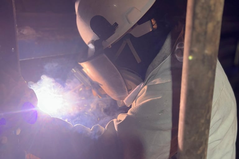 a man in a helmet welding a pipe into a pipe