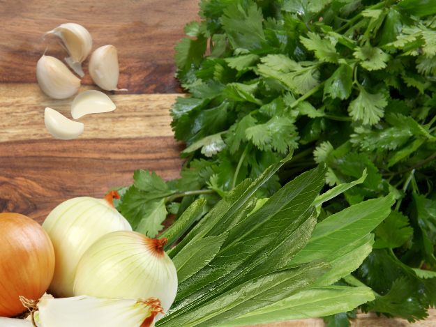 a bunch of vegetables and herbs on a cutting board