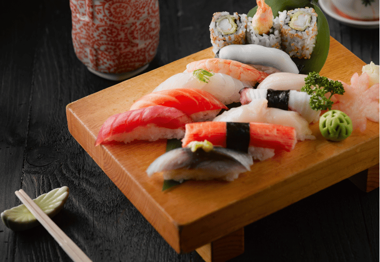 a wooden cutting board with sushi and chopsticks