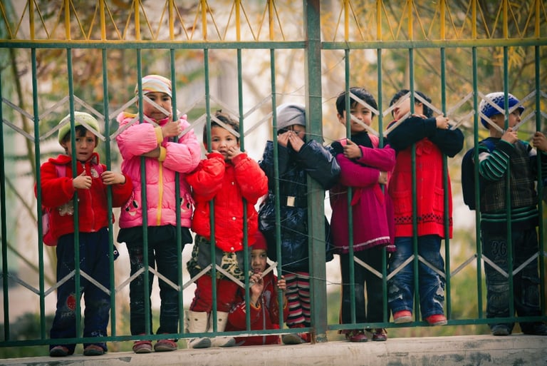 Students in red jackets standing on a wooden bridge during a nature walk, participating in outdoor e