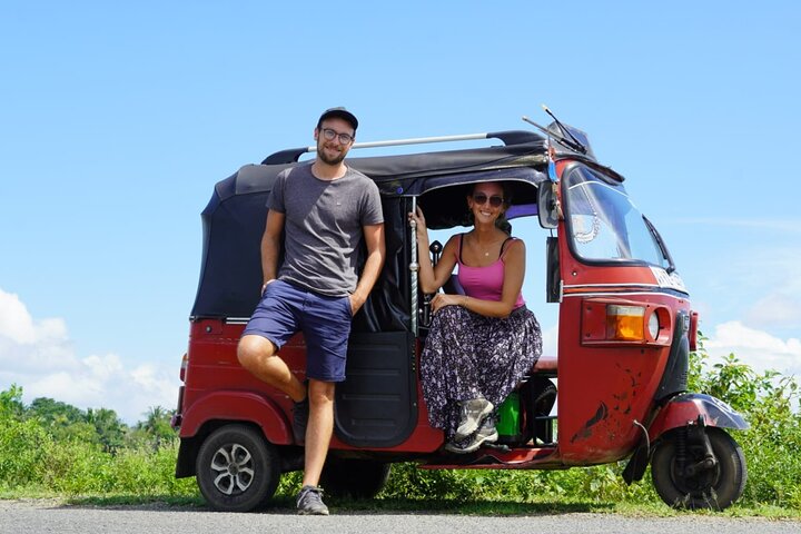 a man and woman standing in front of a tuk tuk tuk
