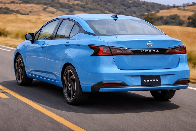 Nissan Versa 2027 azul visto pela traseira em movimento na estrada