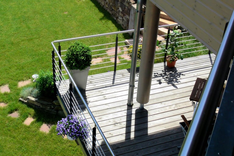 Blick vom oberen Balkon auf unteren Balkon und untere Gartenebene