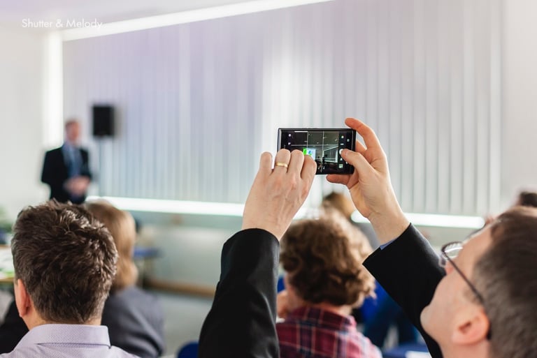 Ein Konferenzteilnehmer nimmt ein Video auf.
