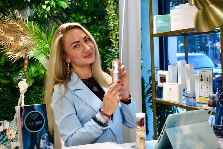 a licensed esthetician in blue lab coat is holding a bottle of perfume