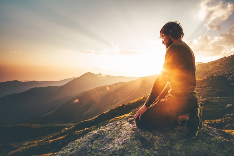 Person meditating peacefully at sunrise representing spiritual balance and inner peace