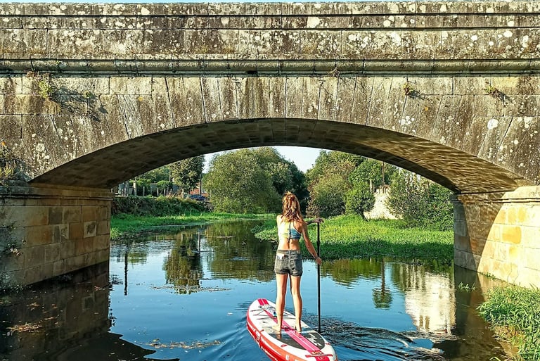 Chica remando en paddle surf en el río sar de Padrón.