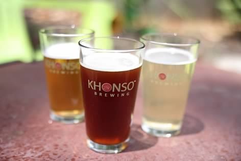 Three glasses of Khonso Brewing craft beer including amber ale and lager on a table.