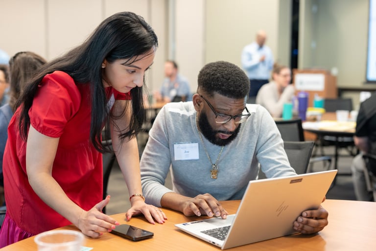 Leadership Austin session, two participants focus intently on a laptop screen