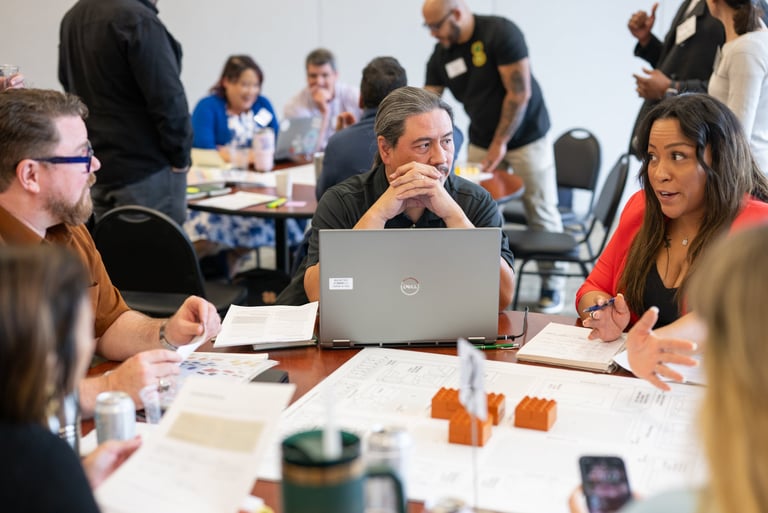 At a Leadership Austin class, participants gather around a table for a lively group discussion