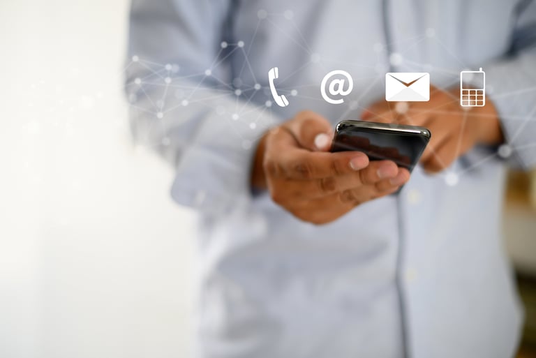 a man in a blue shirt is holding a cell phone