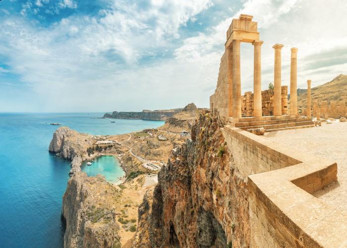 Ancient ruins of the Acropolis of Lindos overlooking the blue Aegean Sea and St. Paul's Bay in Rhodes, Greece.
