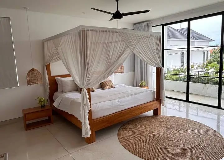 Cozy bed facing tropical greenery in a modern Balinese villa