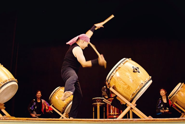 taiko artist Mark H Rooney drumming on stage