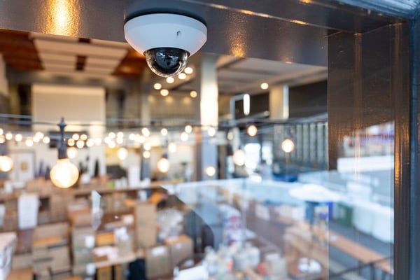 Ceiling-mounted dome surveillance camera overlooking restaurant