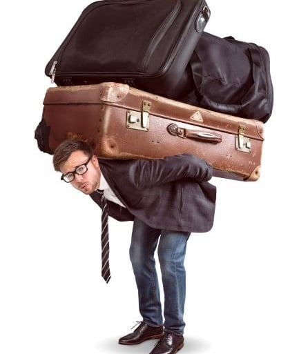 a man carrying too much luggage