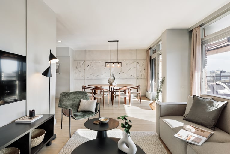 Elegant living room with contemporary furniture, custom art, and neutral tones designed by SAVIA