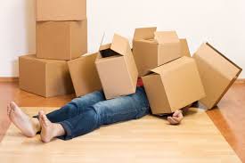 Overwhelmed person buried in boxes, highlighting the need for Swift Movers’ partial packing help