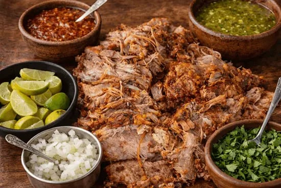 Barbacoa de res tradicional con salsa, cebolla, cilantro y limones en Querétaro.