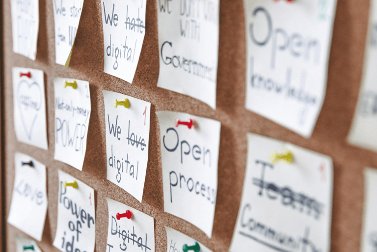 Prikbord vol post-its met woorden, symbool voor teamreflectie en gedeelde inzichten.