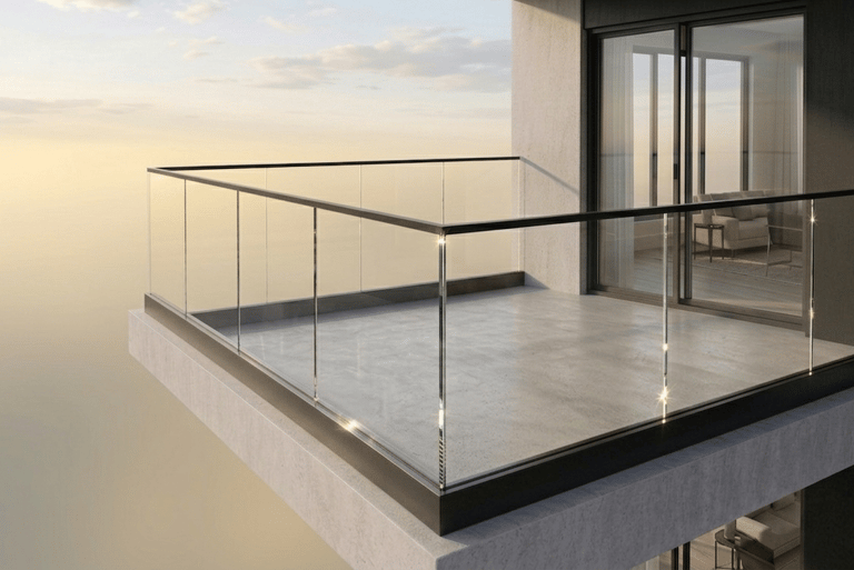 Modern high-rise apartment balcony featuring glass railings and a stunning sunset view.