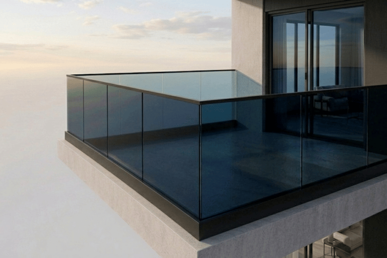 Modern high-rise apartment balcony featuring a sleek black-framed glass railing system at sunset.