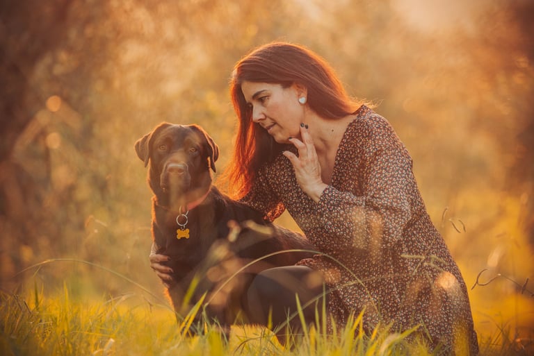 donna con cane su sfondo tramonto arancione