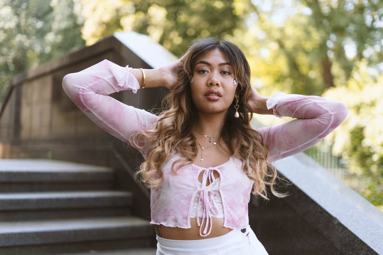 Pretty model in pink top posing in front of stairs