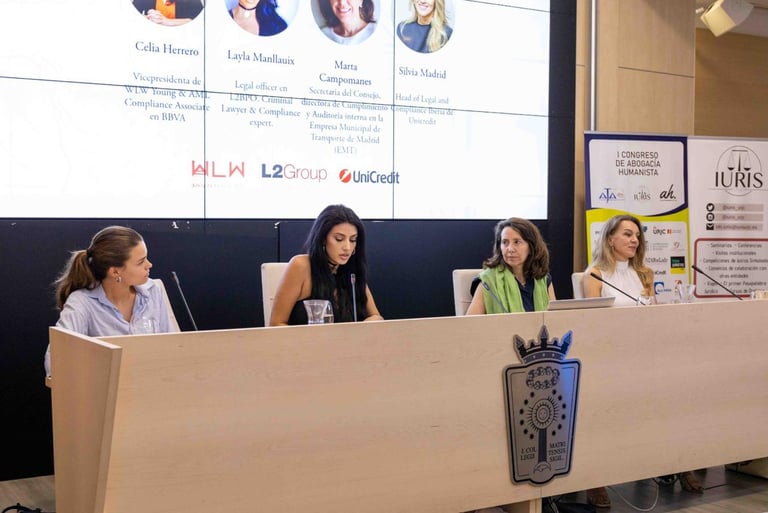 Female legal professionals speaking at a law conference panel discussion with corporate logos displayed.