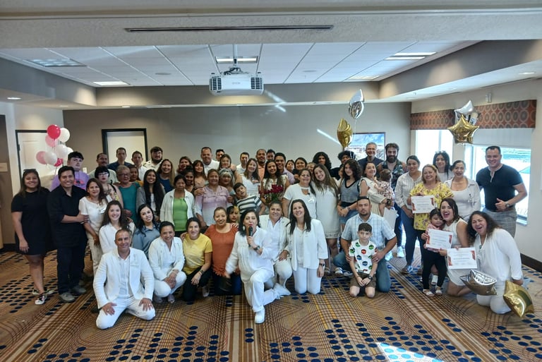A large group of people posing for a group photo at a celebratory event in a conference room.