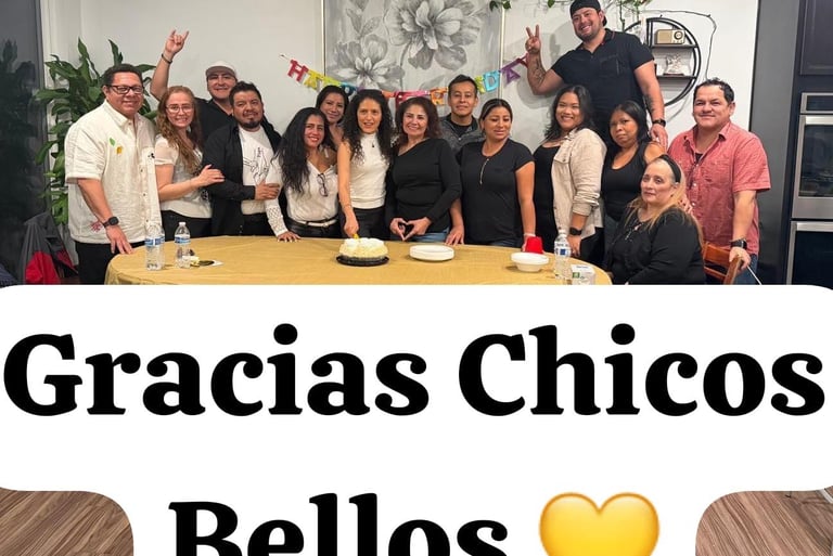 A large group of friends and family gathered around a birthday cake for a festive indoor celebration.