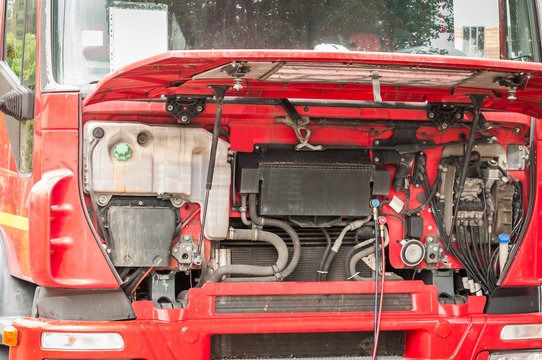 Red semi truck cab with the hood open