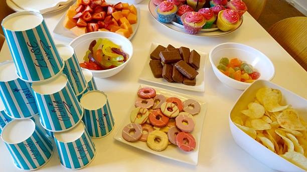 Photo de bonbons, gâteaux, chocolats, gobelets, invitant les jeunes à un goûter