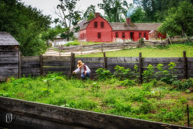 Photo of historically dressed farmer and red barn