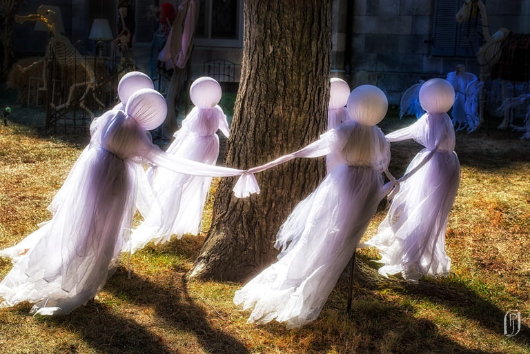 Photo of Halloween ghosts dancing around a tree