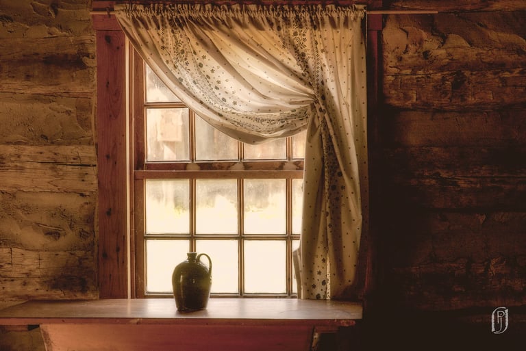 Photo of jug sitting on table in front of log cabin window