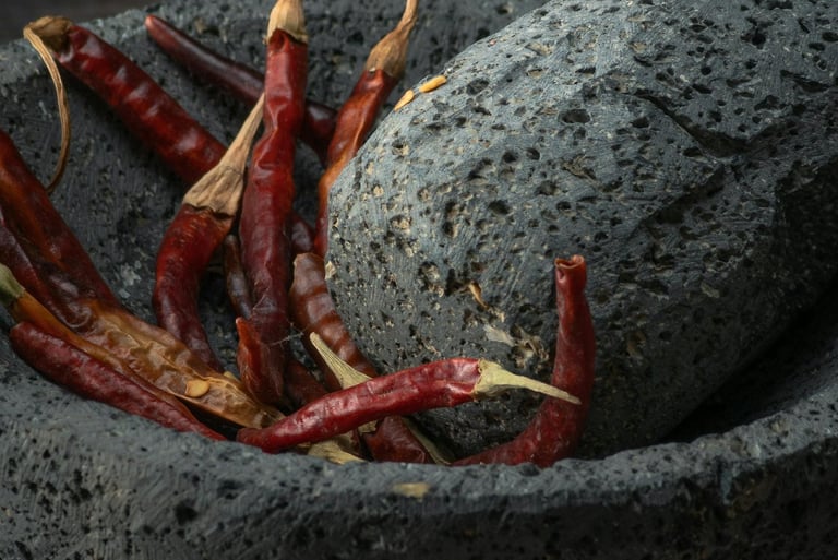 Mortero de piedra tradicional con chiles secos, destacando la tradición y calidad de los productos d